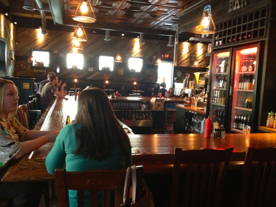 The bar is close to all of the tables.